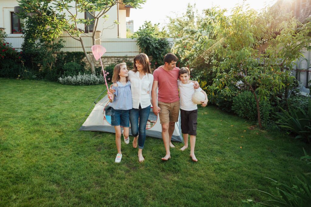 Rodzina spaceruje po ekologicznym, zielonym ogrodzie Giardini Polska; przykład zrównoważonego krajobrazu BREEAM.